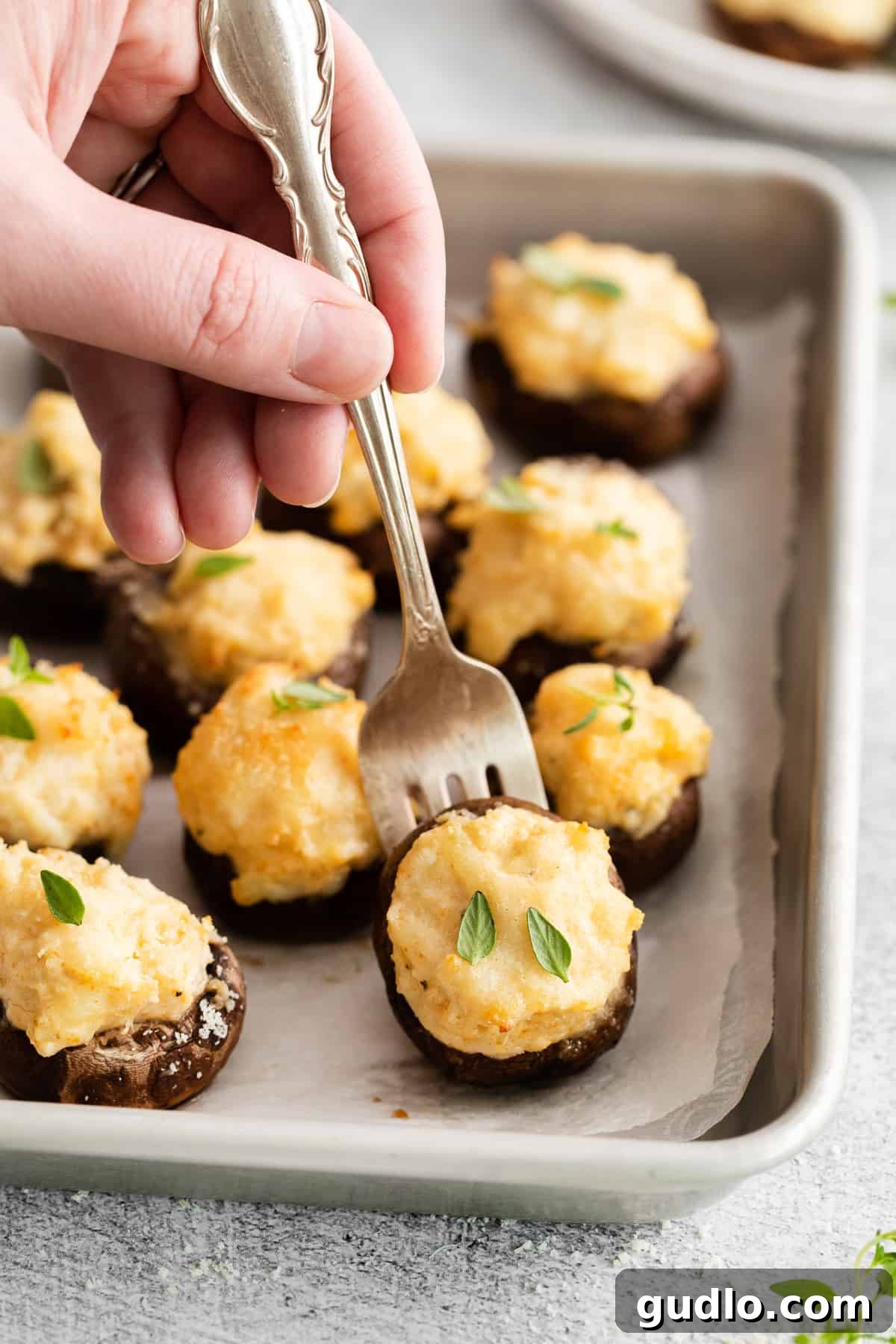A single crab stuffed mushroom on a fork, showing the creamy filling.