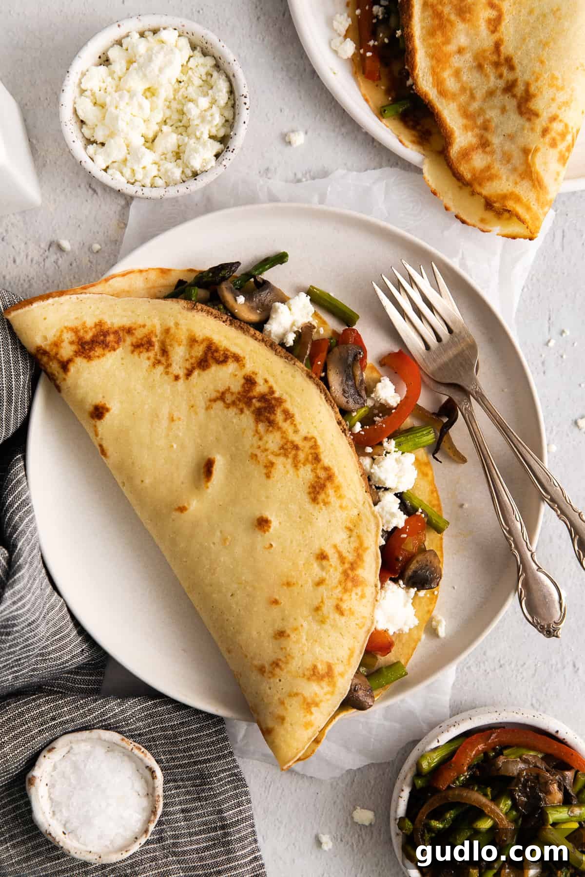 Deliciously Folded Goat Cheese Crepe on a Plate A perfectly cooked goat cheese crepe, elegantly folded and presented on a white plate, ready to be served.