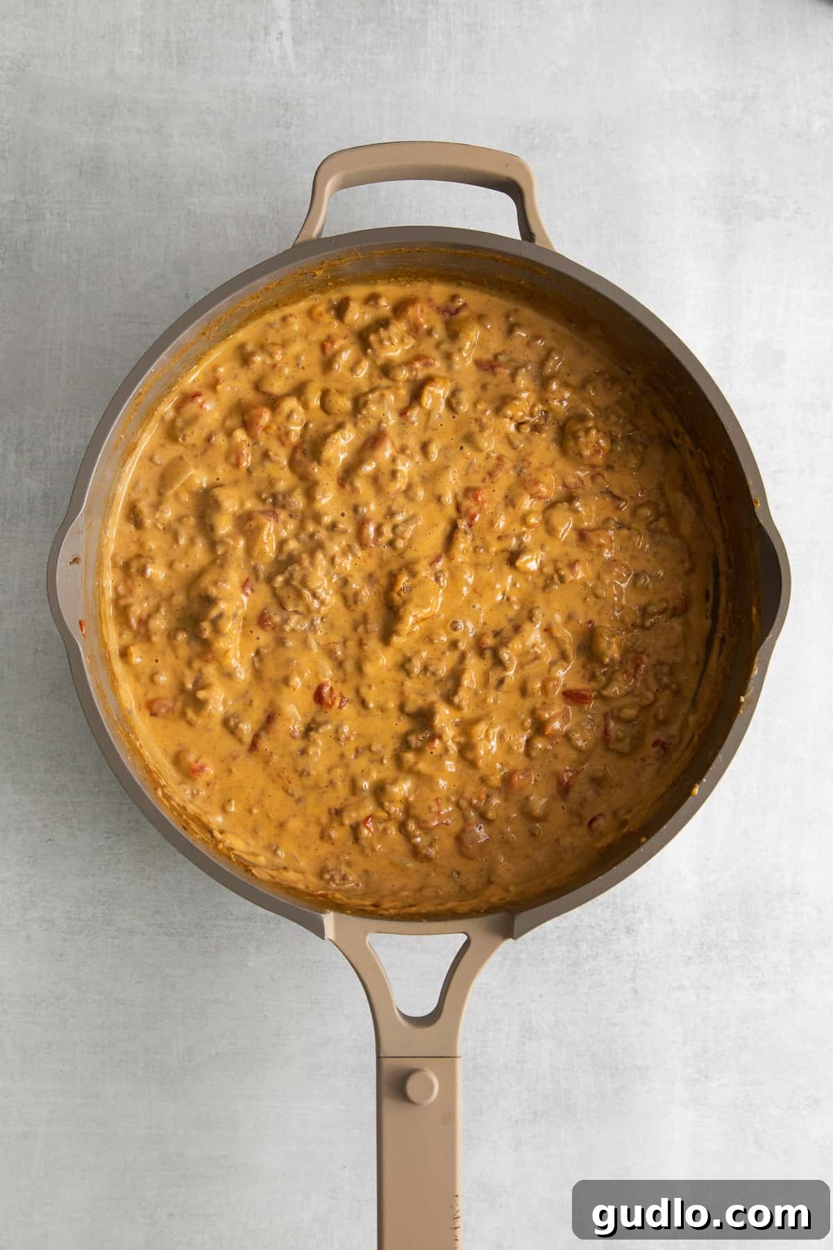 A large skillet brimming with hot, perfectly melted Rotel dip, showcasing its creamy texture and ready to be served.