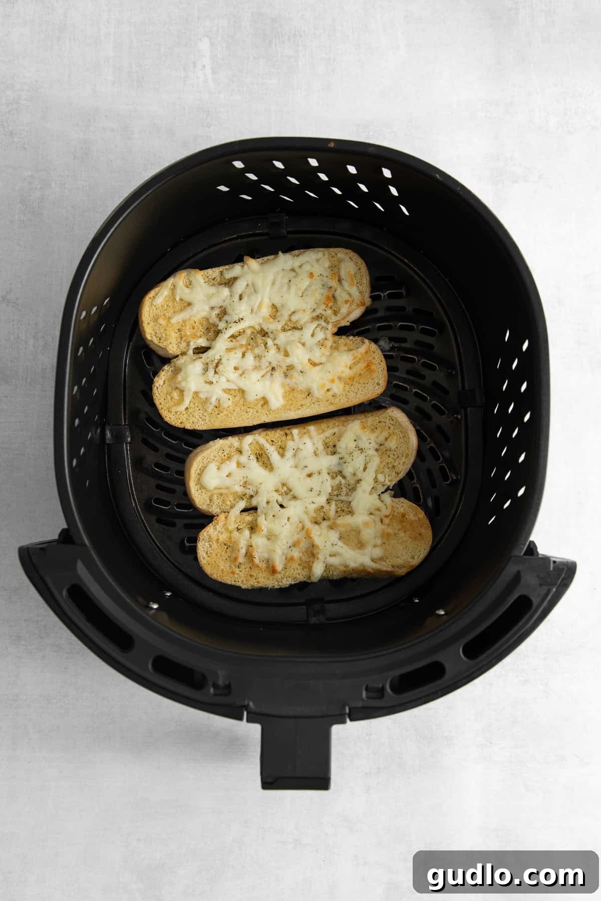 Air Fried Cheesy Italian Dunkers Italian dunkers baking to perfection in an air fryer, showcasing their golden cheese topping.