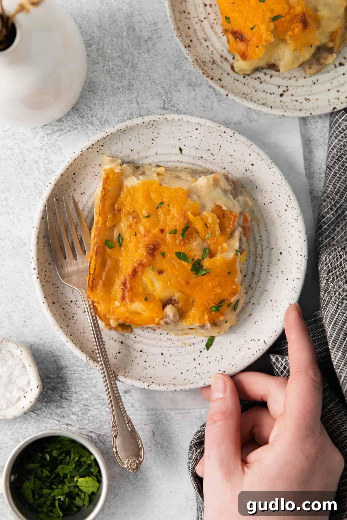Golden-Topped Cheesy Shepherd's Pie 8 A perfect slice of cheesy shepherd's pie served on a plate with a fork, ready to be enjoyed.