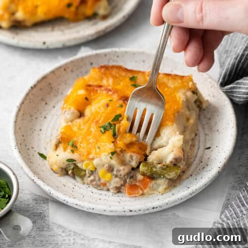 Golden-Topped Cheesy Shepherd's Pie 9 A full cheesy shepherd's pie in a square baking dish, ready to be served.