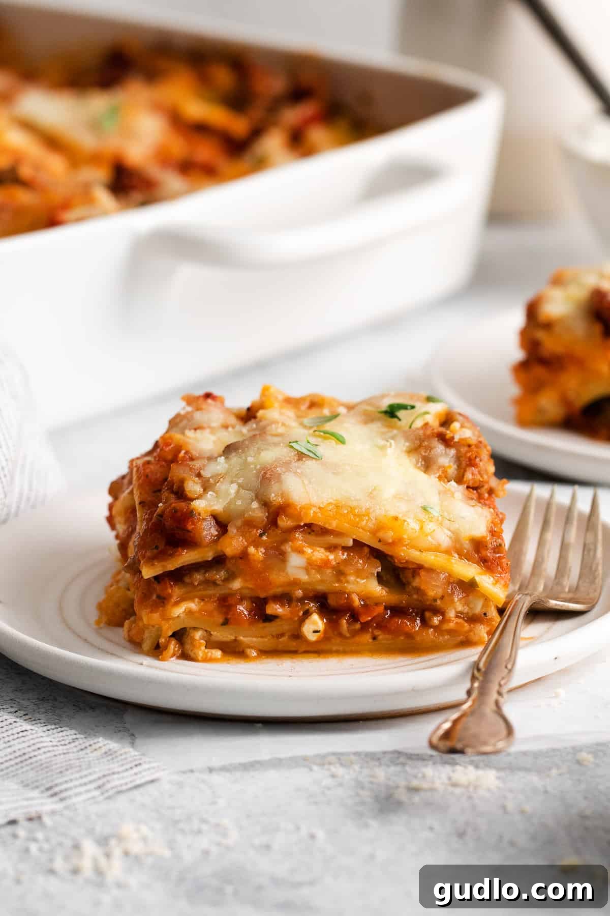 Homestyle Cottage Lasagna 2 A perfectly portioned slice of golden-brown cottage cheese lasagna on a white plate, ready to be enjoyed.