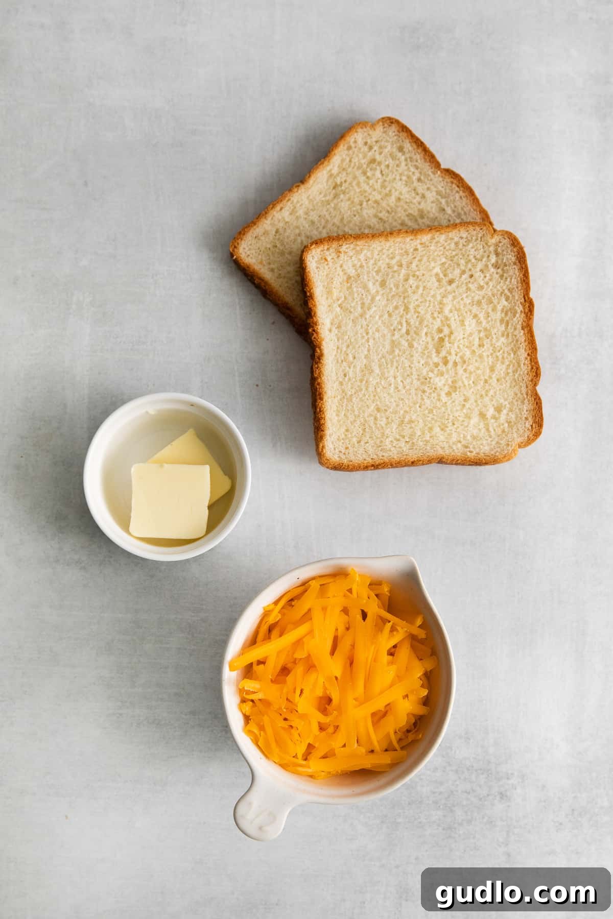 Golden Cheesy Toast 3 A selection of key ingredients for making cheese toast, including Texas toast, shredded cheese, and butter.