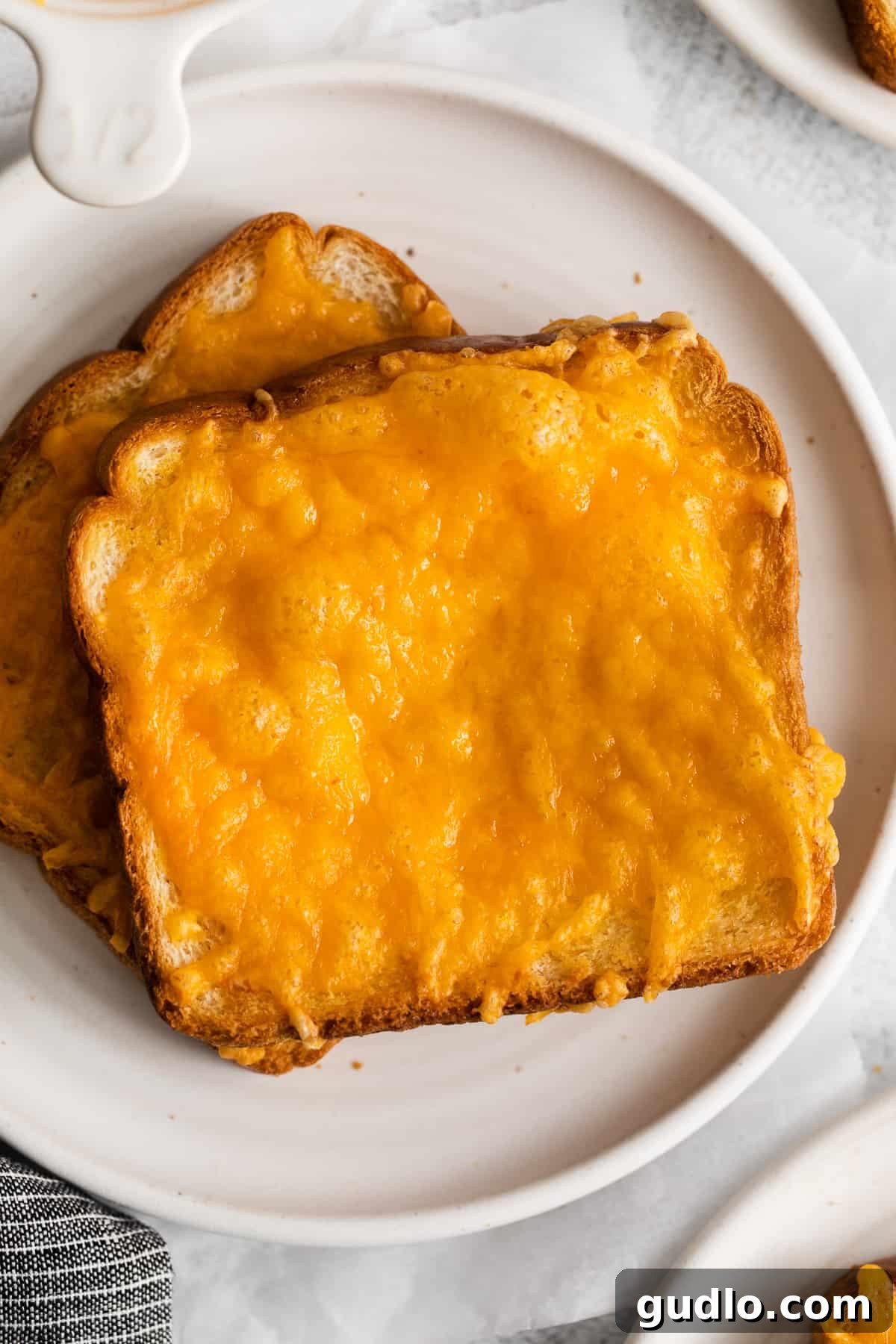 Golden Cheesy Toast 6 A plate of two perfect slices of cheese toast, ready for serving.
