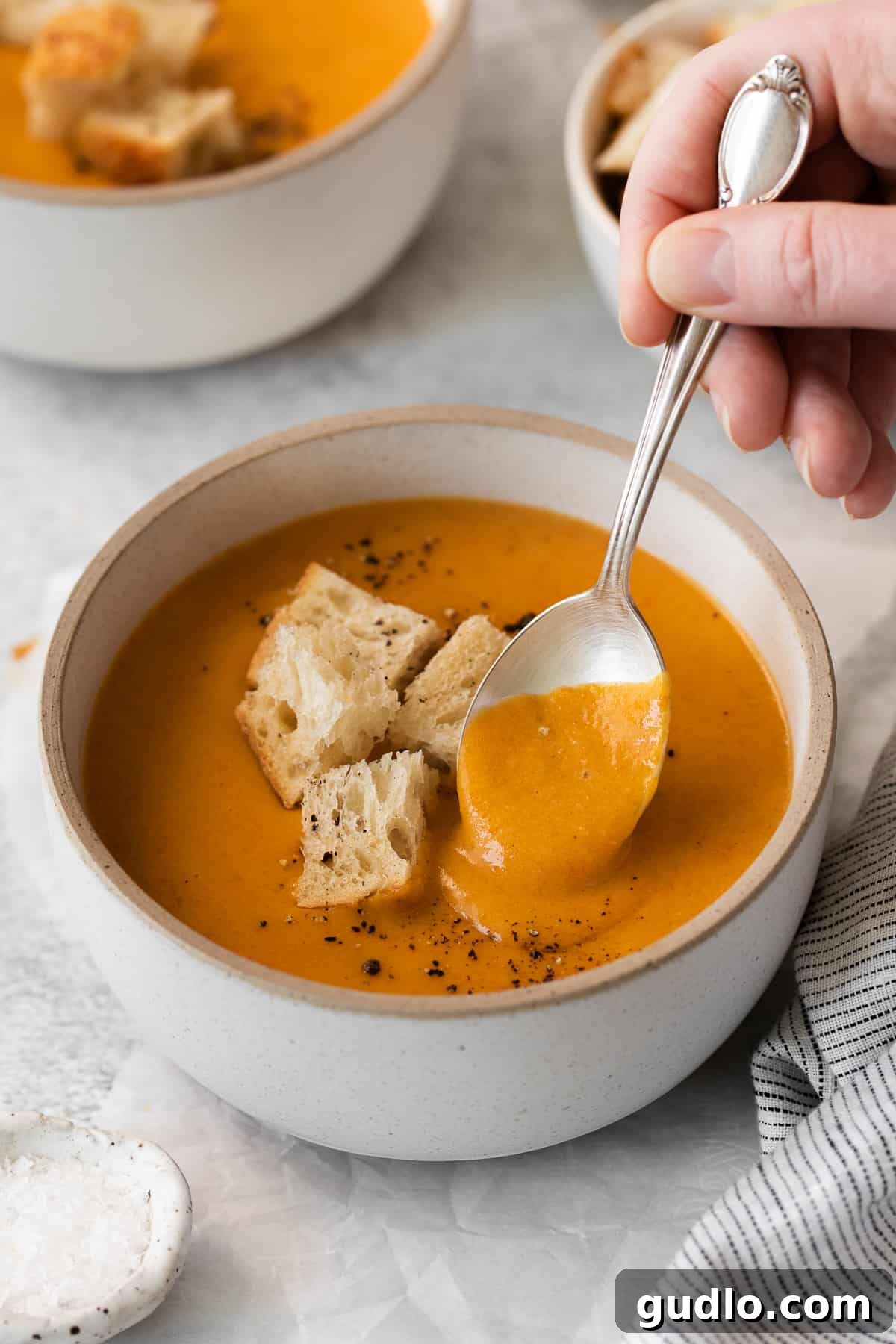 Wisconsin cheese soup in a bowl with a spoon, ready to be enjoyed.