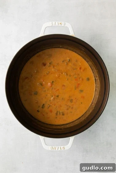 a crock pot filled with soup and vegetables.