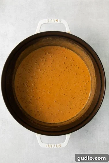 a slow cooker filled with a sauce.
