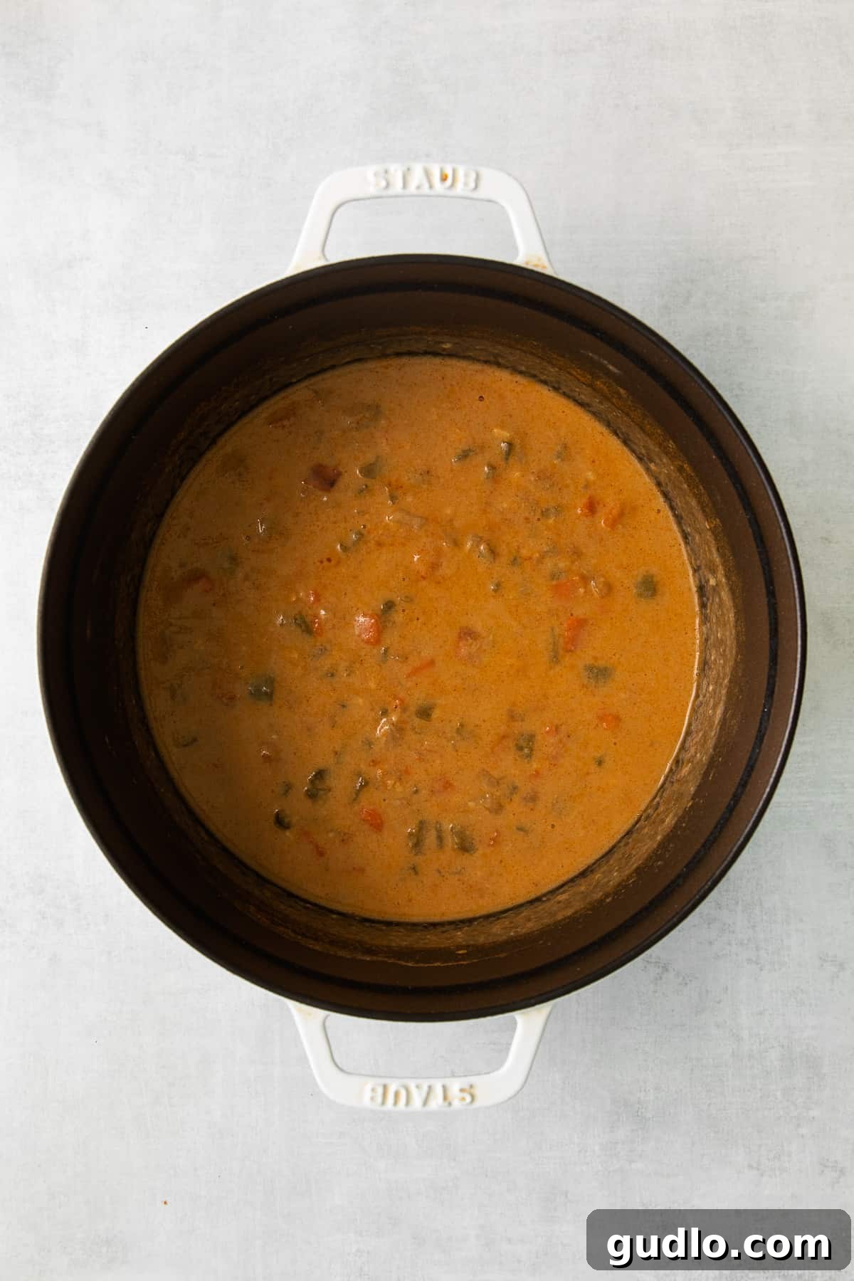 Wisconsin cheese soup simmering in a large stock pot on the stovetop.