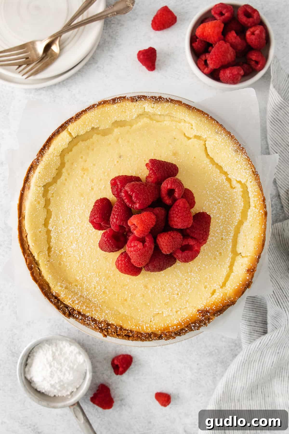 Ricotta cheesecake topped with fresh raspberries, showcasing its creamy texture.