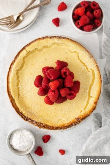 a slice of cheesecake with raspberries on top, ready to eat.