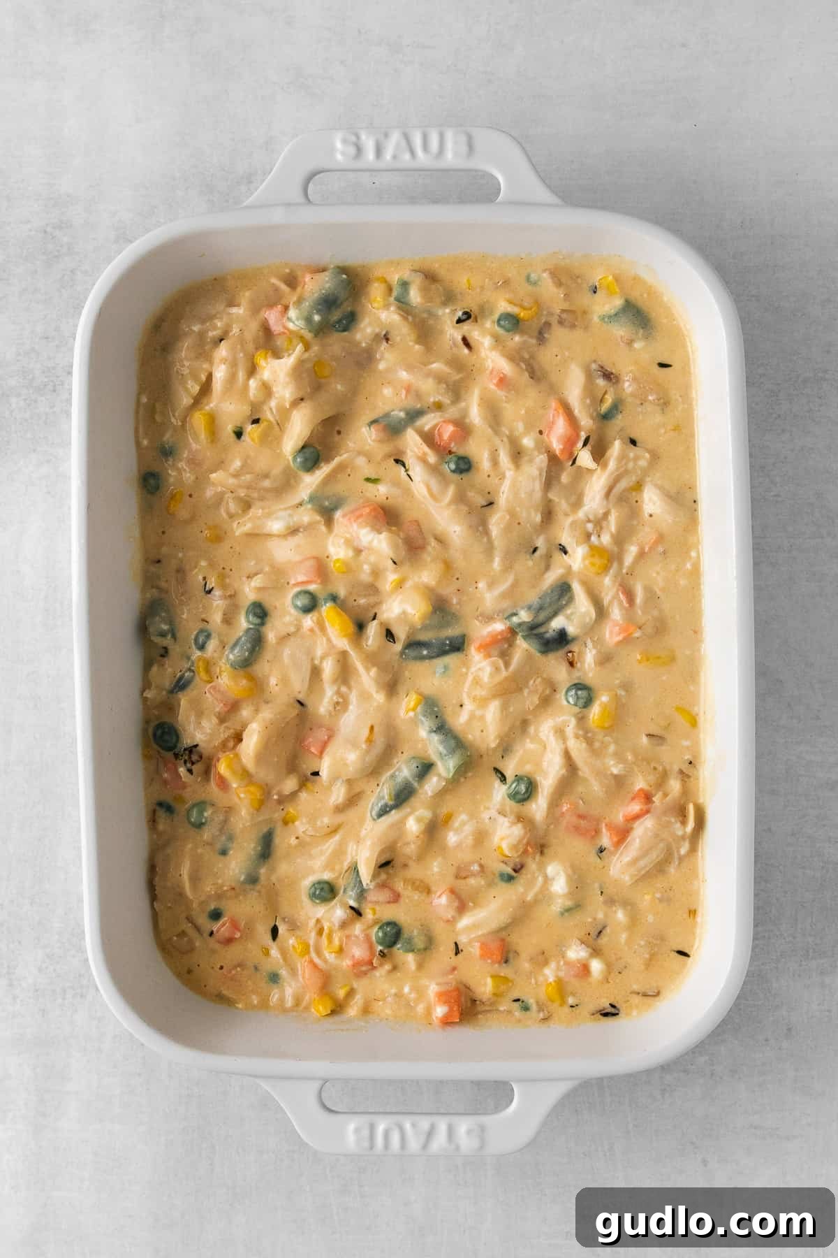 Chicken Pot Pie Casserole Ready to Bake The savory filling of chicken pot pie casserole, topped with puff pastry, ready for the oven.