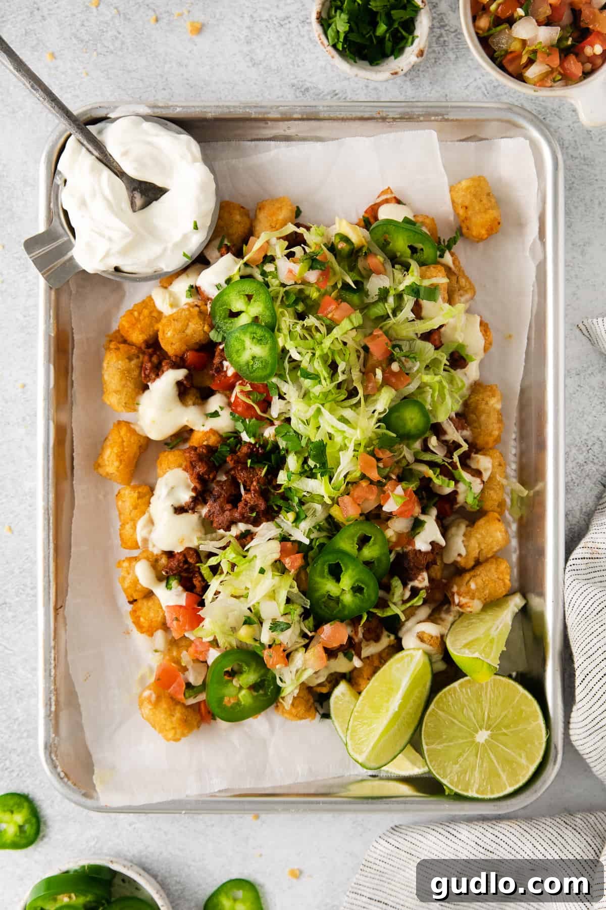 Ultimate Totchos: Tater Tot Nachos Totchos topped with nacho fixings, ready to be enjoyed.