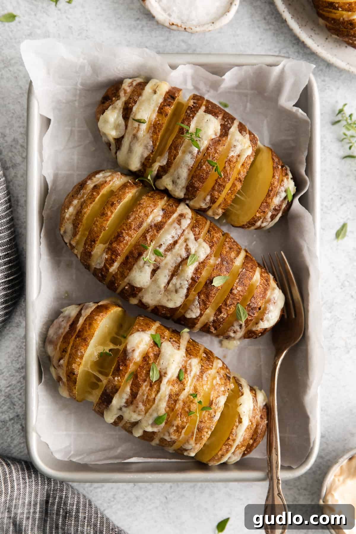 Crispy Air Fryer Hasselback Potatoes with Melted Cheese A perfectly cooked Air fryer hasselback potato on a plate, showcasing its crispy skin and melted cheese.