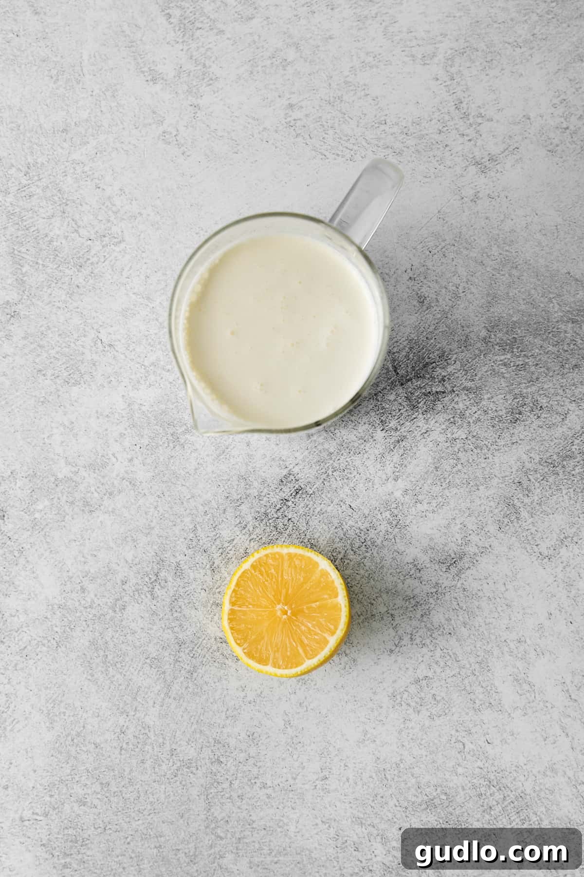 Two simple ingredients, heavy cream and lemon juice, laid out on a clean surface, ready for making mascarpone cheese.