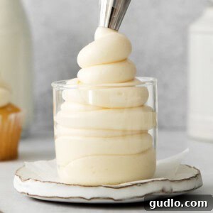 A glass filled with rich, creamy mascarpone frosting, ready to be spread on desserts.