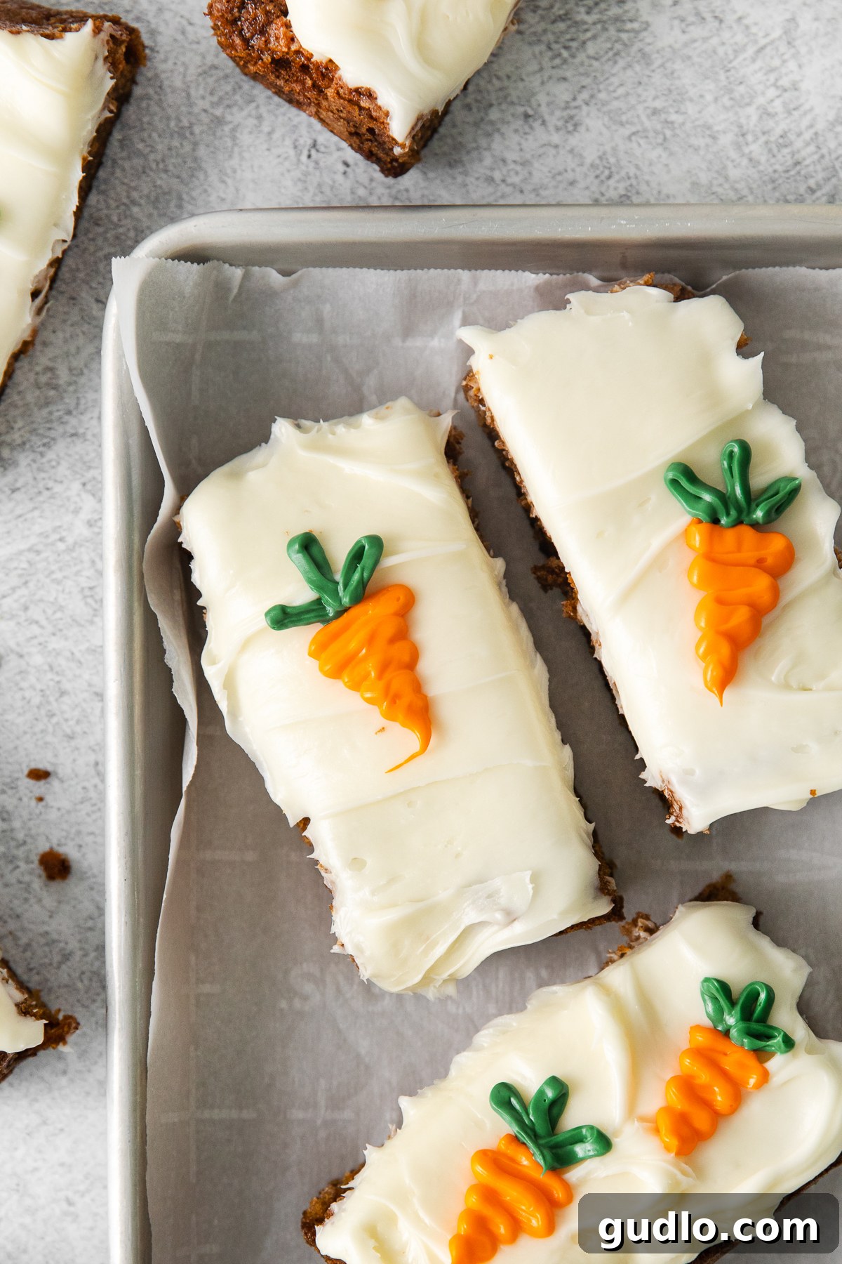 Close-up of a perfectly sliced carrot cake bar, showing the moist cake texture, shredded carrots, and thick cream cheese frosting.