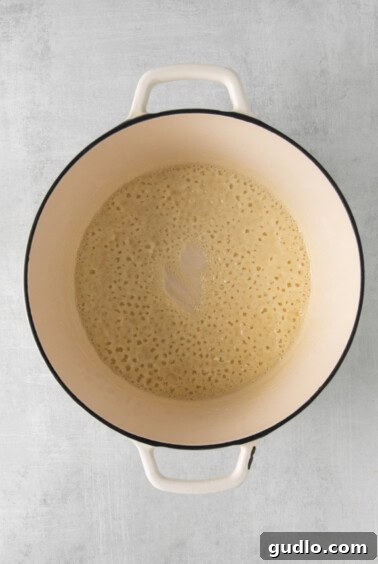 A pot filled with a liquid roux, gently simmering on the stove.