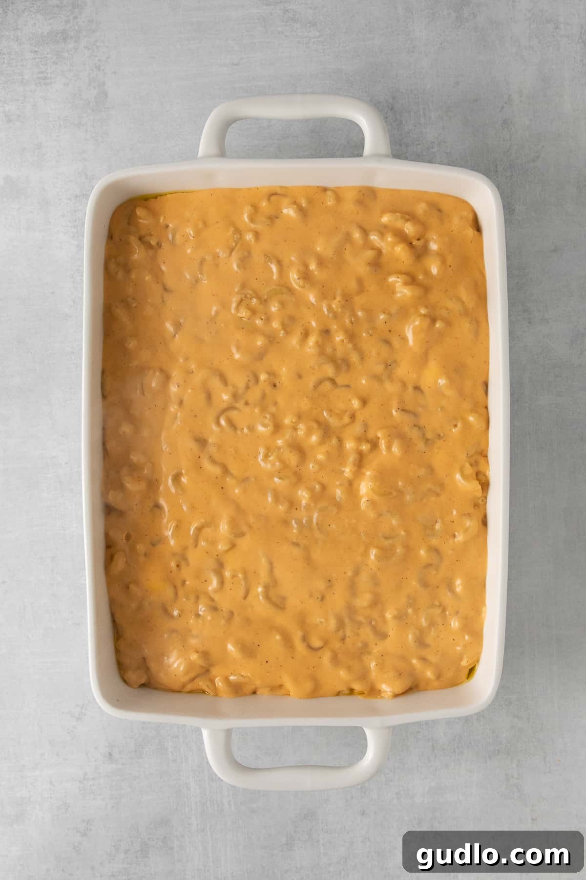 A steaming casserole dish filled with golden-brown Southern baked mac and cheese, fresh from the oven.
