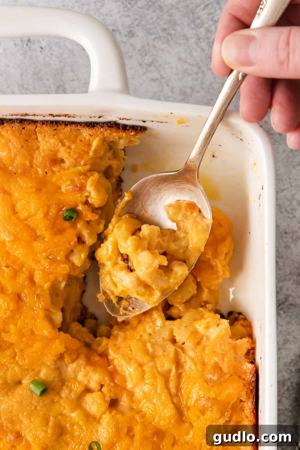 A close-up of Southern baked mac and cheese on a spoon, showcasing its creamy texture and melted cheese.