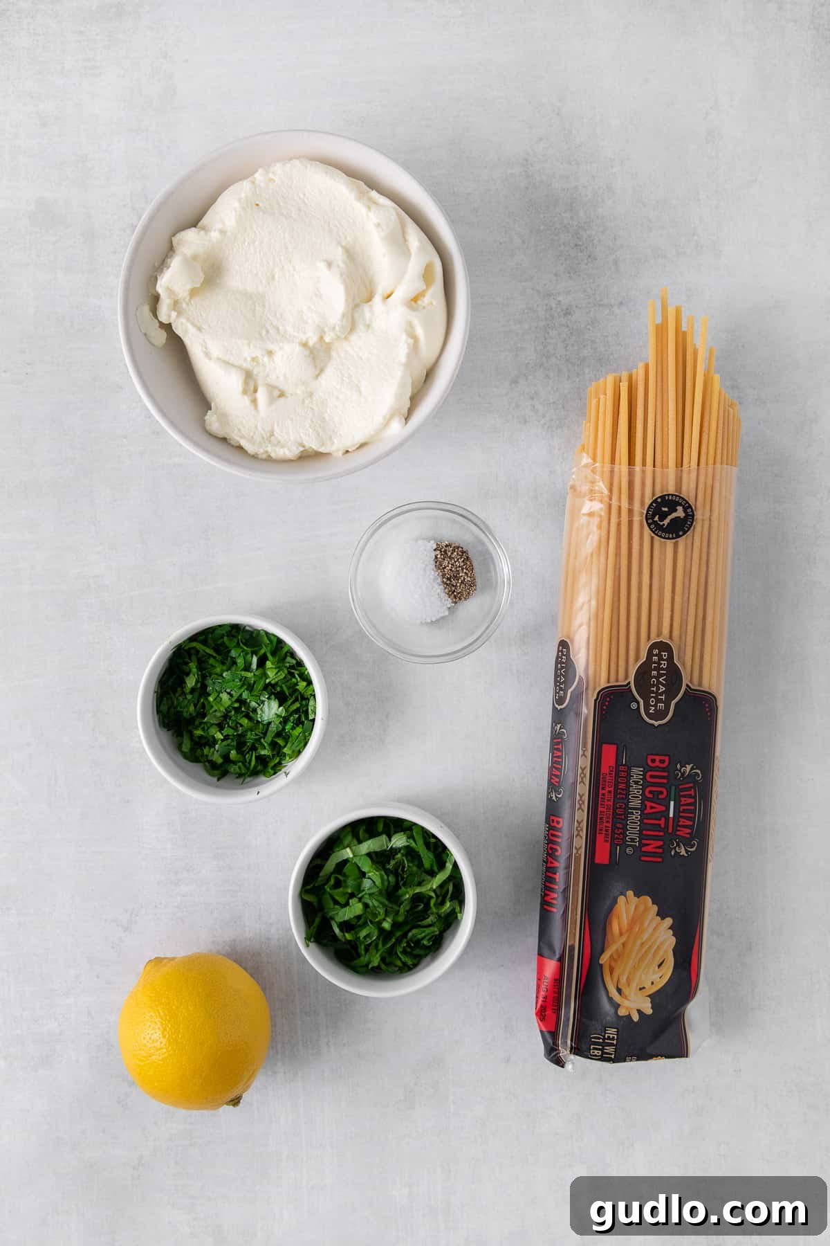 Various ingredients for lemon ricotta pasta laid out in small bowls.