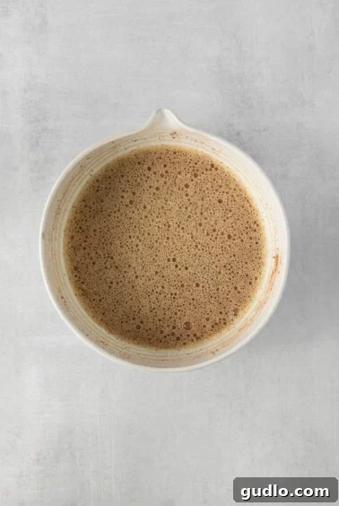A bowl of coffee or custard mixture on a gray surface.