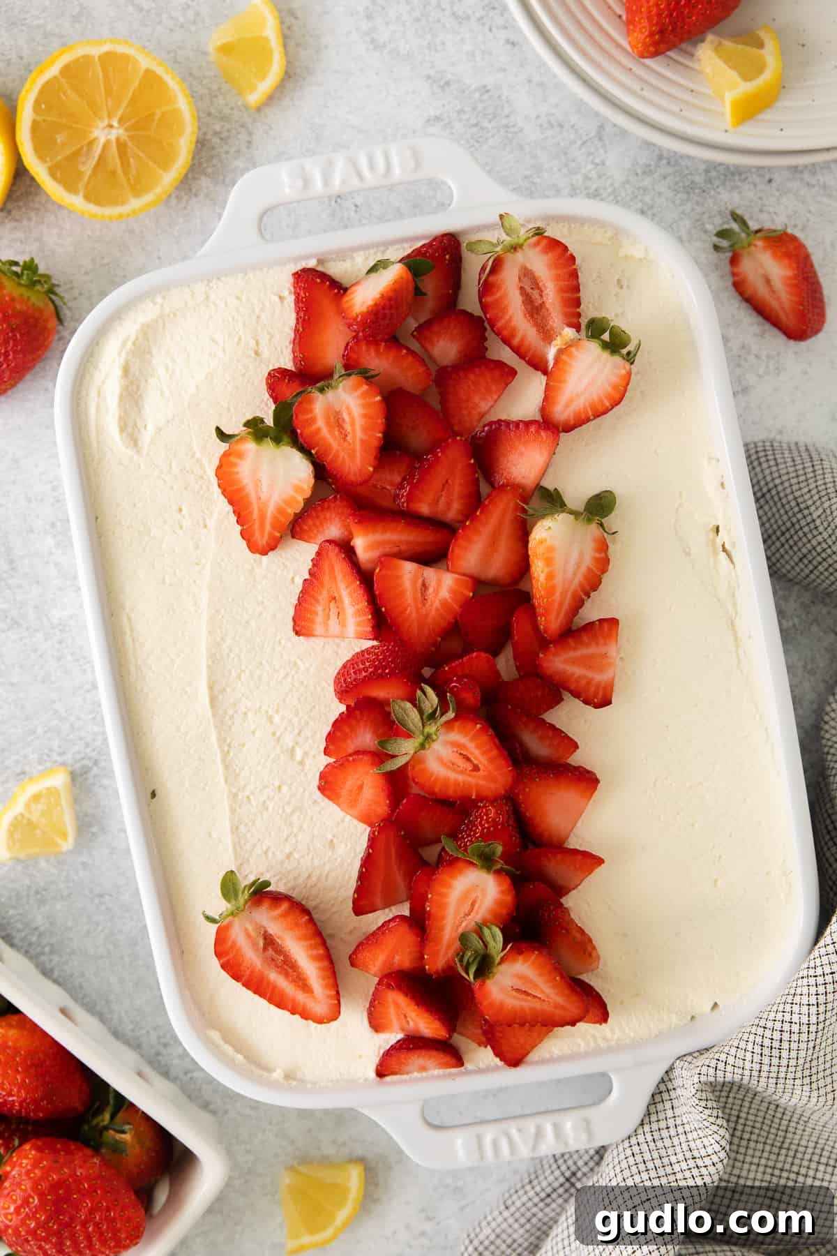 This homemade strawberry tiramisu has layers of flavorful mascarpone filling and prosecco-drenched ladyfingers. It is a fruity twist to this traditional no-bake dessert. Strawberry tiramisu topped with a generous amount of sliced fresh strawberries, ready to be served.