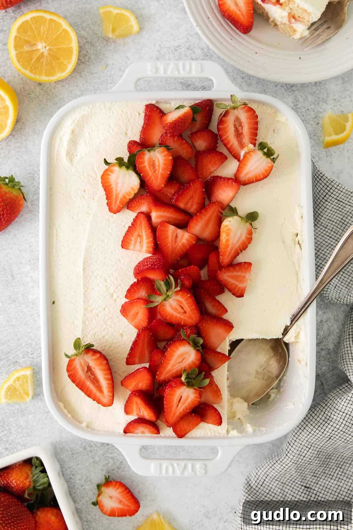 This homemade strawberry tiramisu has layers of flavorful mascarpone filling and prosecco-drenched ladyfingers. It is a fruity twist to this traditional no-bake dessert. Strawberry tiramisu in a baking dish, with a spoon ready to scoop out a serving.