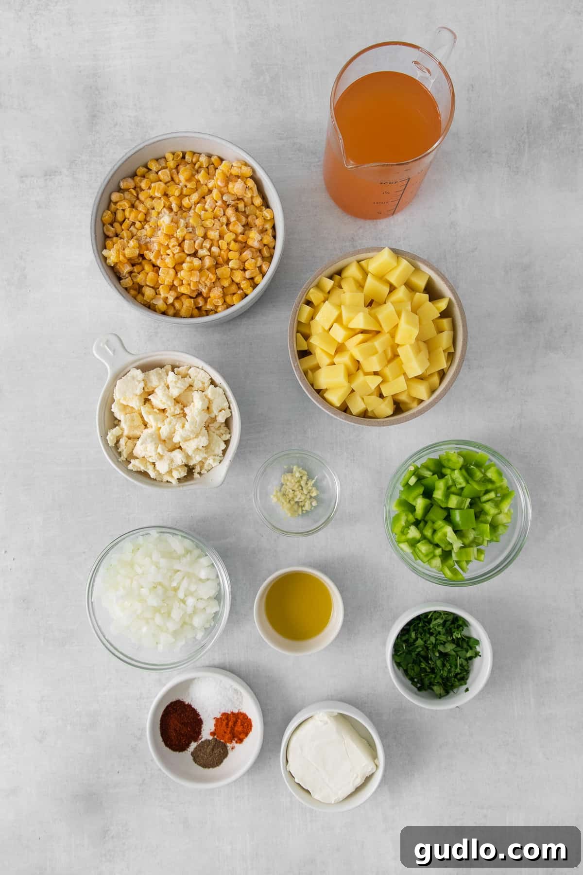 A vibrant collection of ingredients for Mexican Street Corn Soup laid out in bowls, including corn, poblano peppers, cotija cheese, and fresh lime.