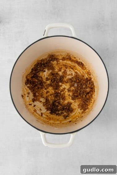 A pot with sautéed onions, garlic, and spices, forming the flavorful base for the soup.