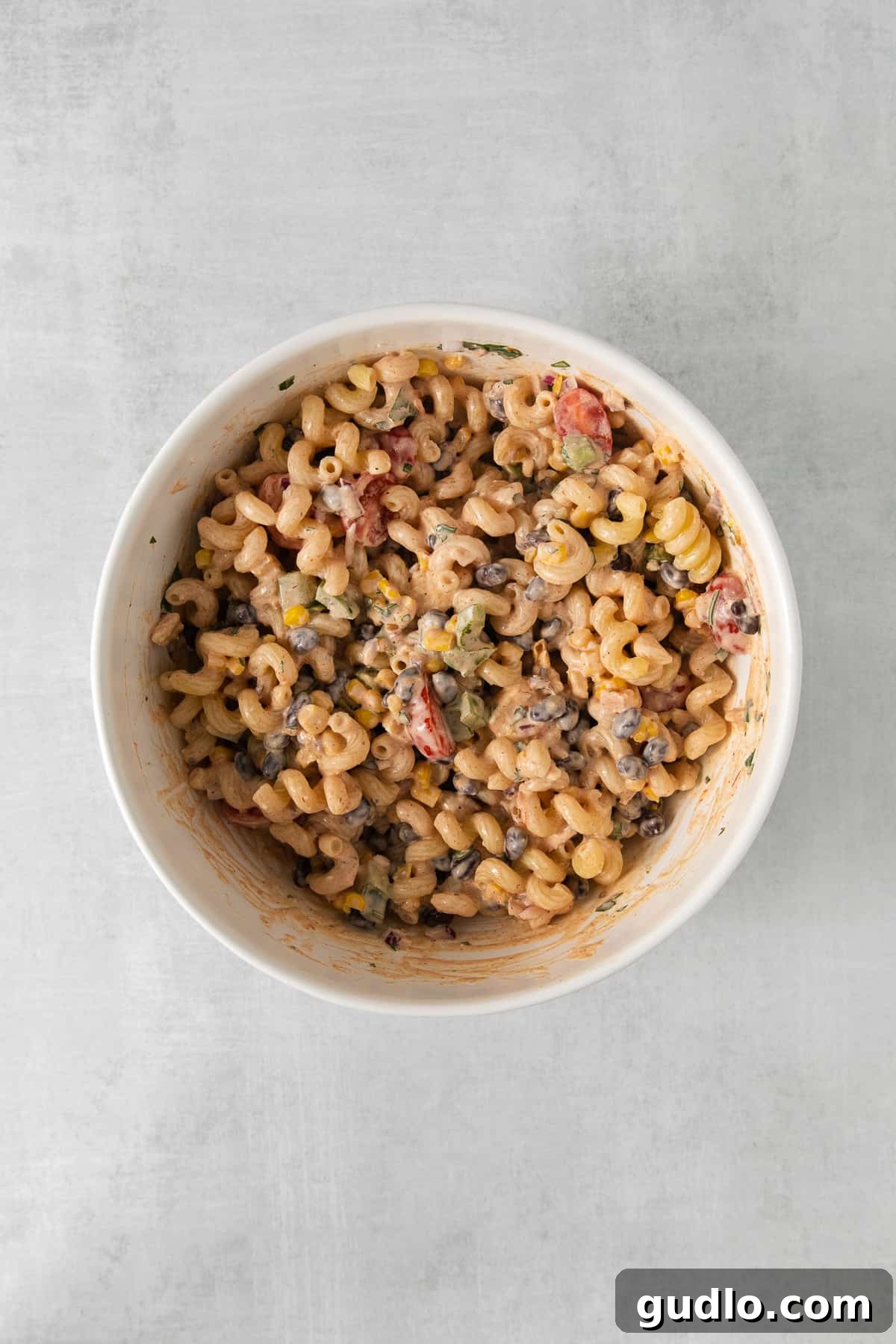 Fiesta Pasta Salad 5 A vibrant bowl of Mexican pasta salad, showcasing the colorful mix of ingredients and creamy dressing, topped with fresh cilantro.