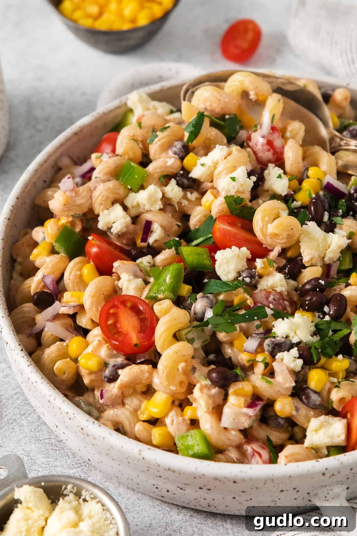 Fiesta Pasta Salad 10 A close-up shot of the Mexican pasta salad in a bowl, showing the intricate mix of ingredients and the rich texture of the dressing.