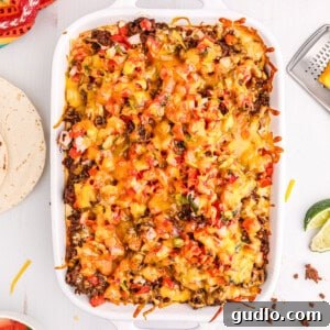 Ultimate Taco Mac and Cheese 2 Hearty taco lasagna in a large casserole dish, with layers of meat, cheese, and tortillas.