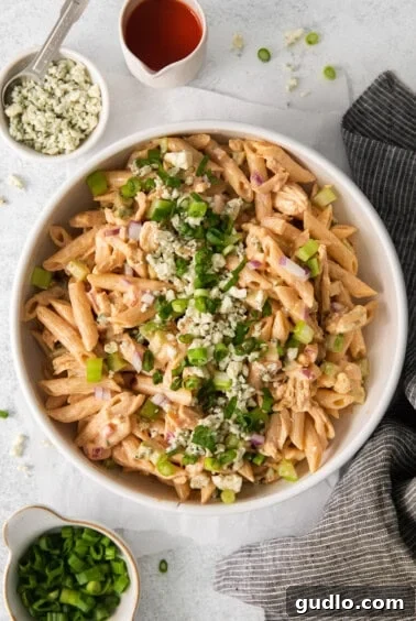 The complete buffalo chicken pasta salad, with pasta, chicken, and vegetables coated in creamy dressing, presented in a pristine white bowl, ready to be enjoyed.