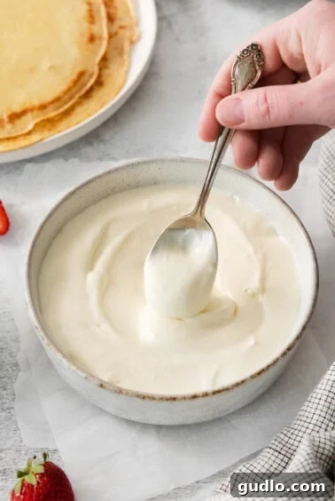 A bowl of creamy strawberry cream cheese filling being mixed.