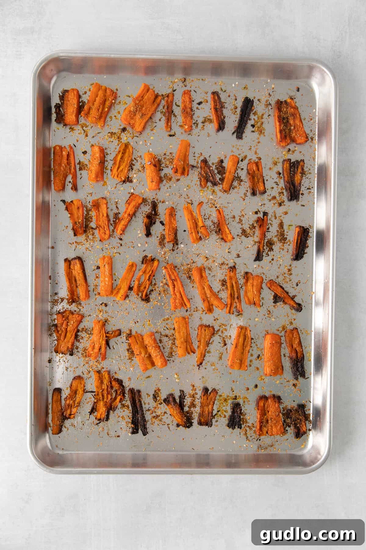 Baked Parmesan Smashed Carrots Golden-brown Parmesan smashed carrots arranged neatly on a baking sheet after being perfectly baked.