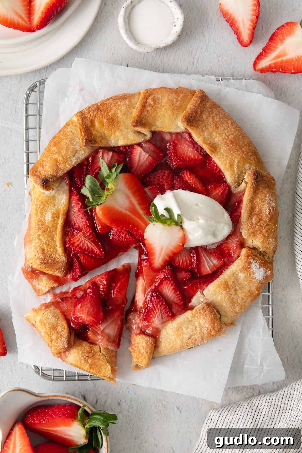 A stunning strawberry cream cheese tart with a golden, flaky crust and vibrant fresh strawberries, resting elegantly on a cooling rack.