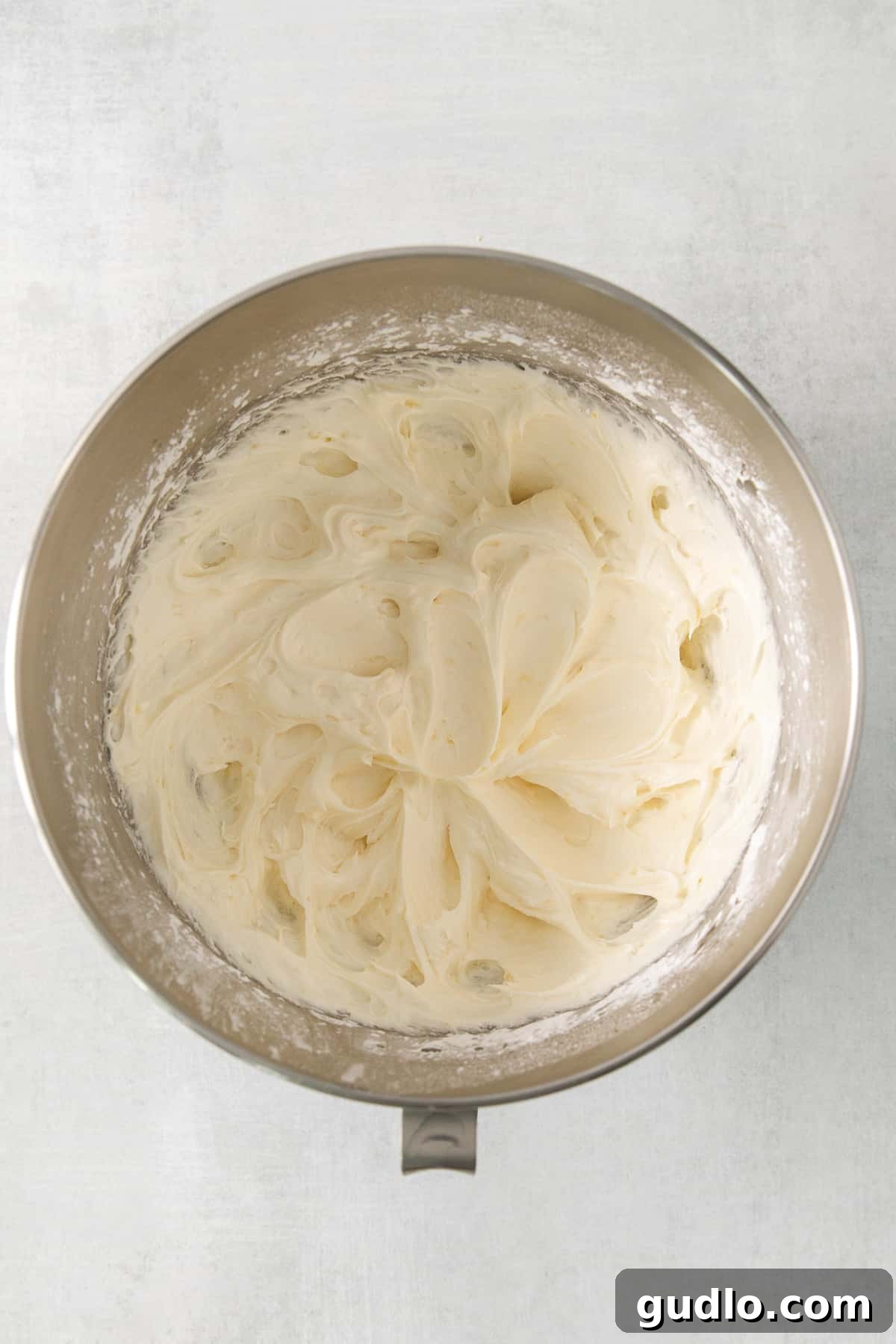 Creamy Whipped Lemon Frosting Expertly whipped lemon cream cheese frosting, smooth and fluffy, nestled in a metal bowl, ready for spreading.