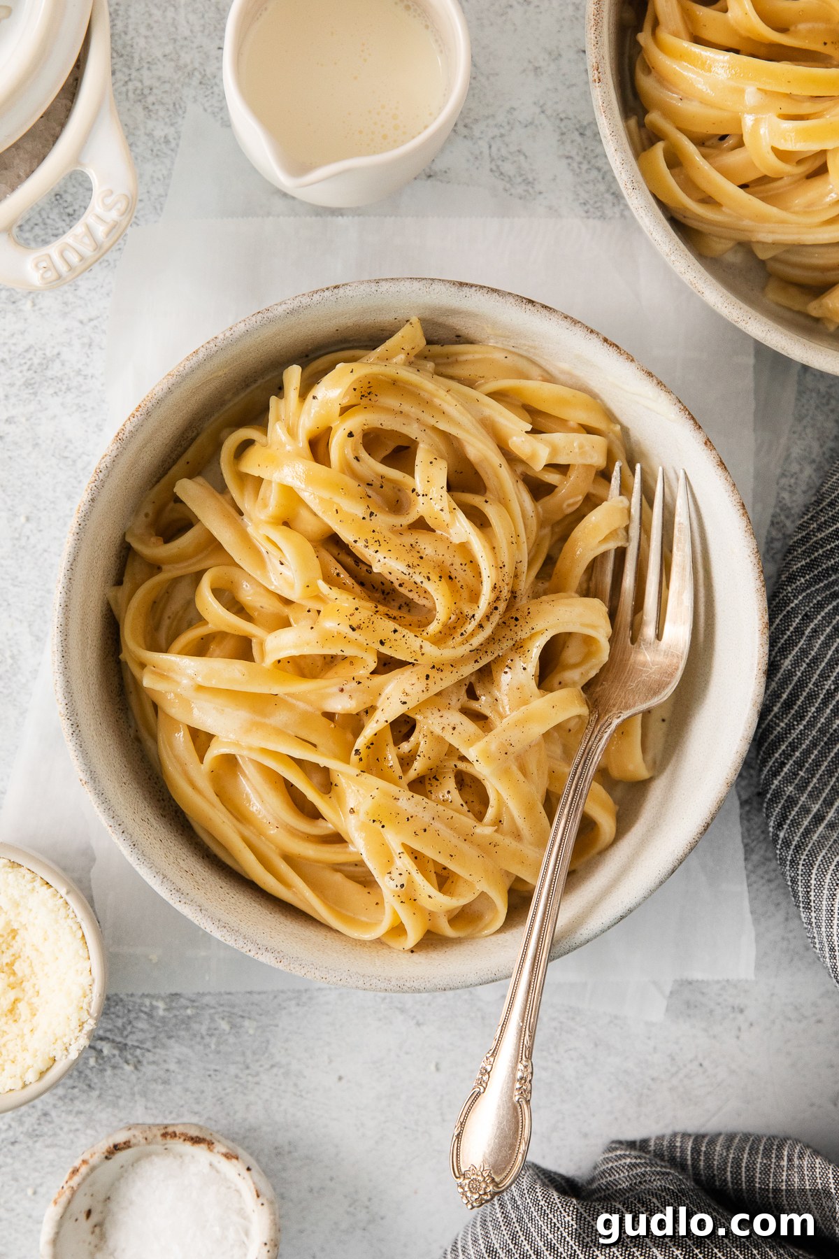 The Best Homemade Alfredo Sauce on Pasta A bowl of creamy Alfredo pasta, garnished with fresh parsley.