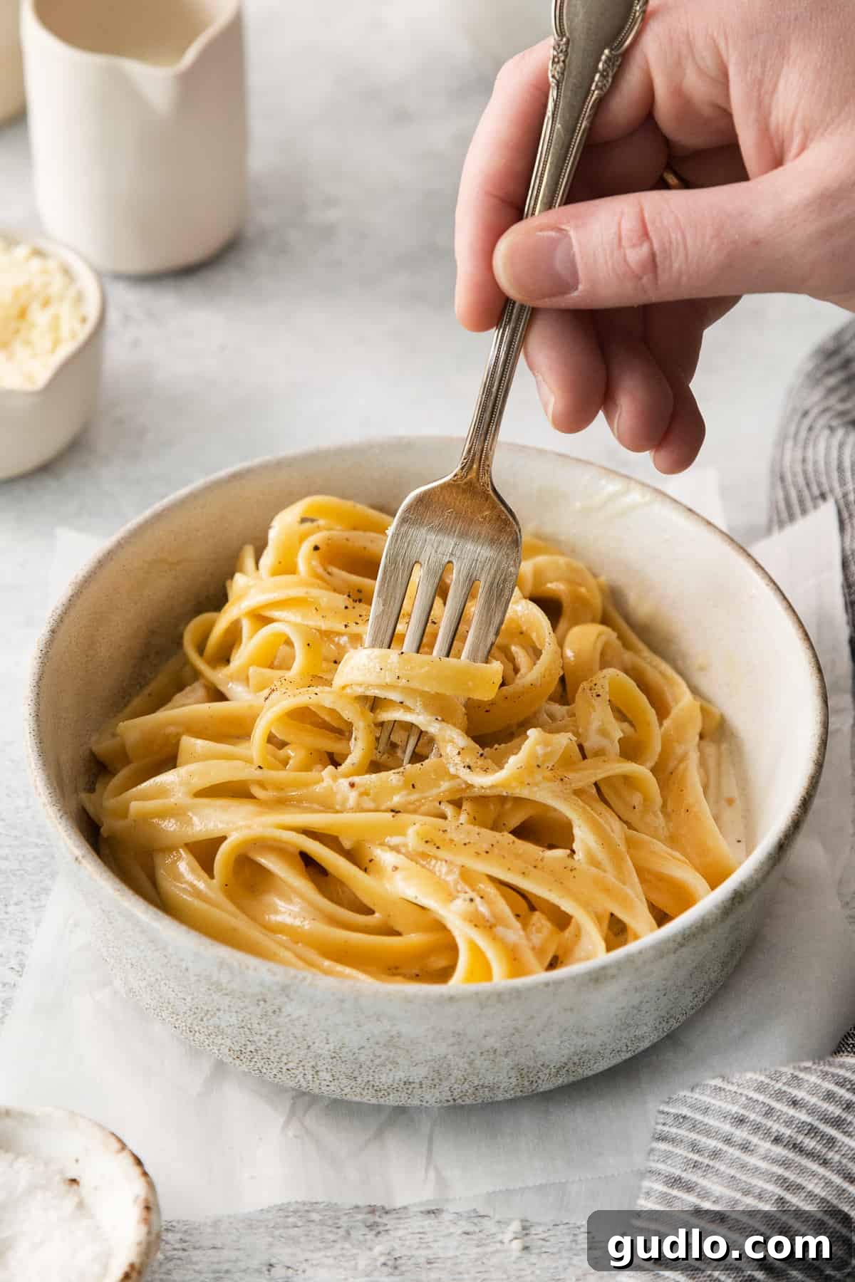 Classic Fettuccine Alfredo Ready to Serve A tantalizing bowl of fettuccine alfredo, garnished with fresh herbs and grated Parmesan.