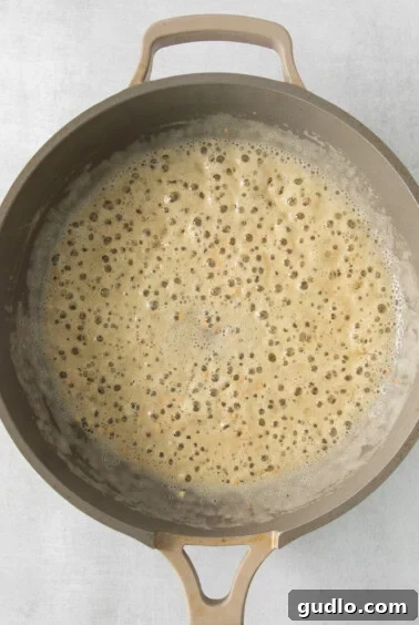 Melted butter and cream in a pan, ready for cheese.
