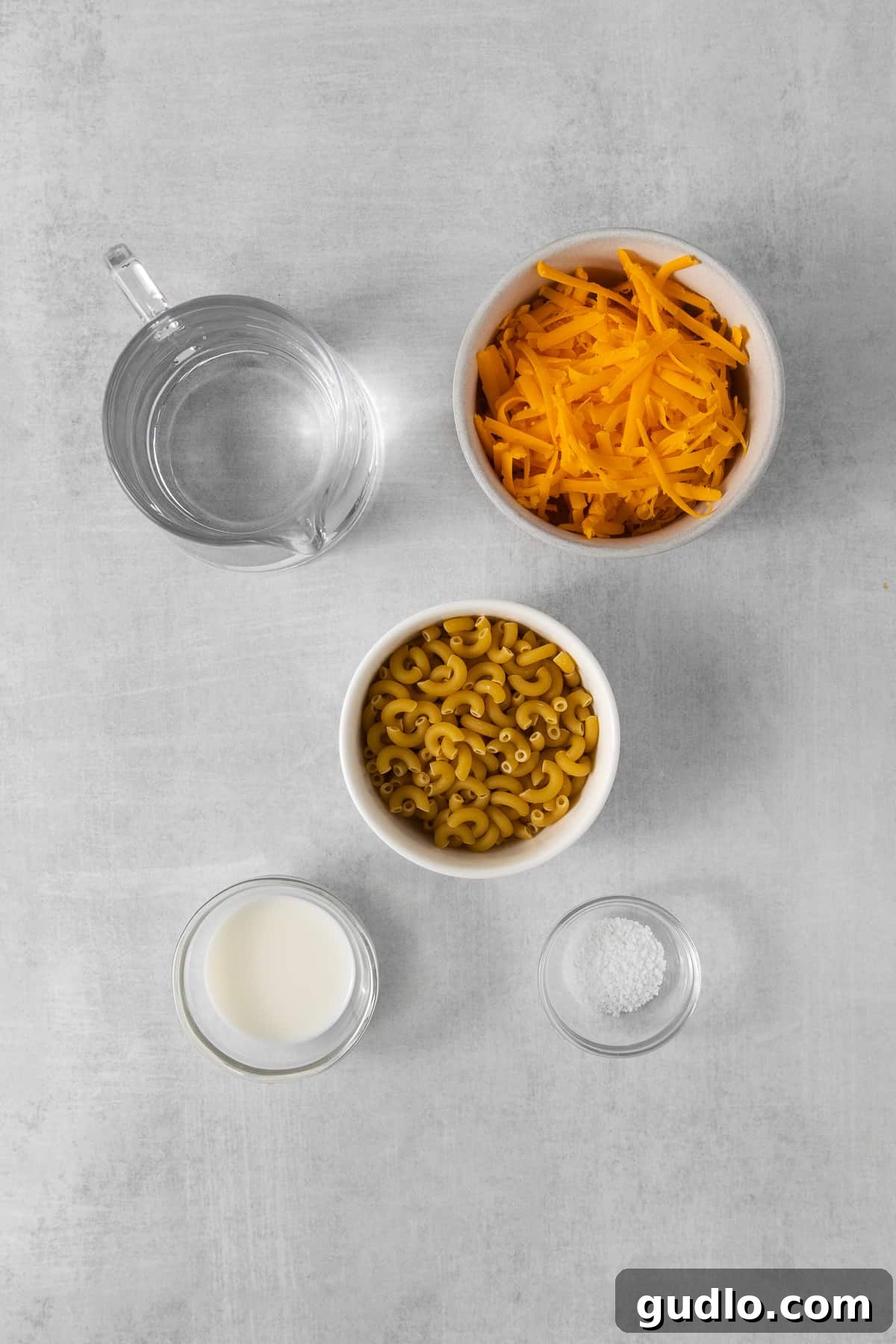Essential Ingredients for Microwave Mac and Cheese Ingredients for microwave mac and cheese laid out in bowls.