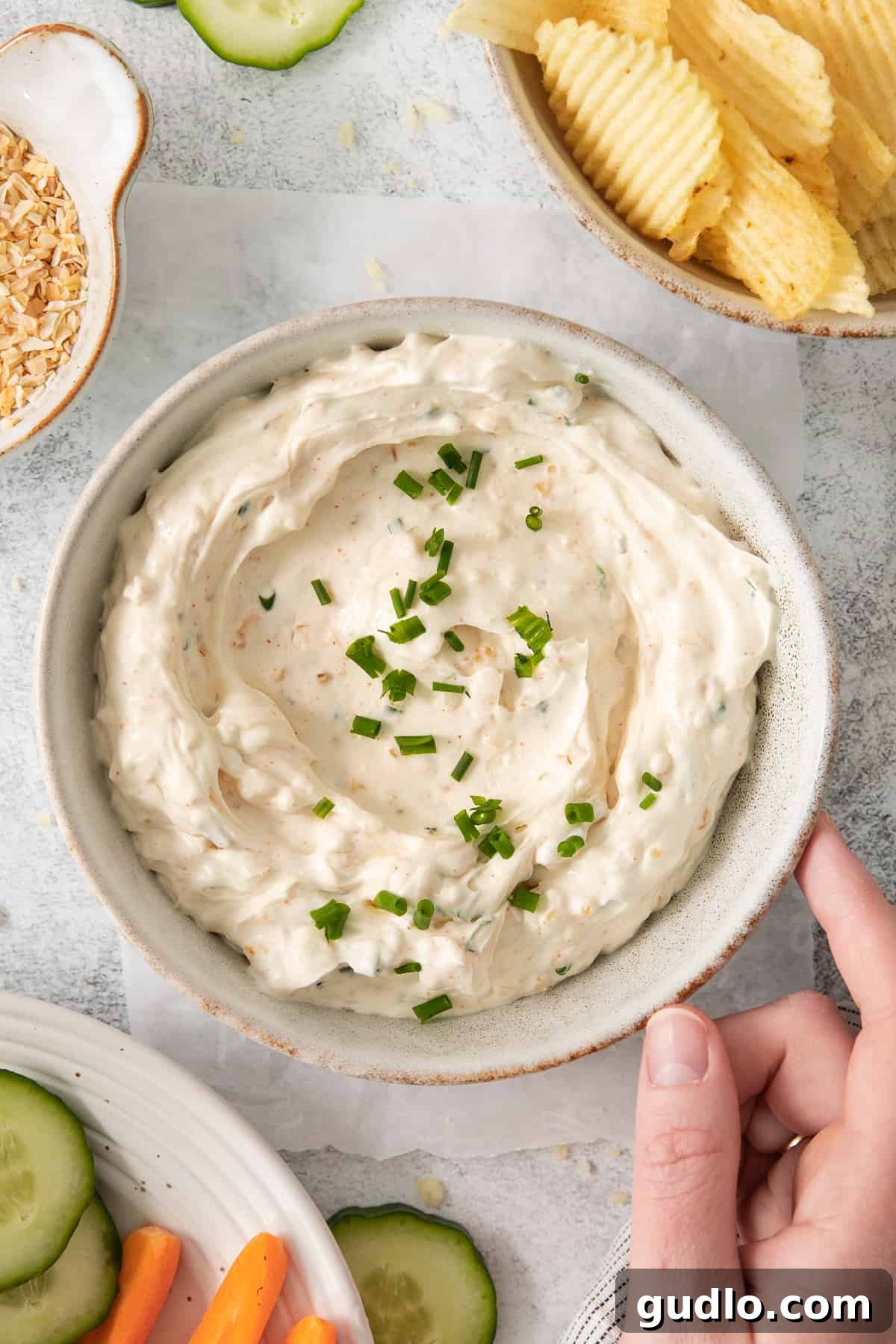 Chip Dip Garnished with Fresh Chives A bowl of classic chip dip generously topped with fresh green chives, showcasing its appetizing appeal.
