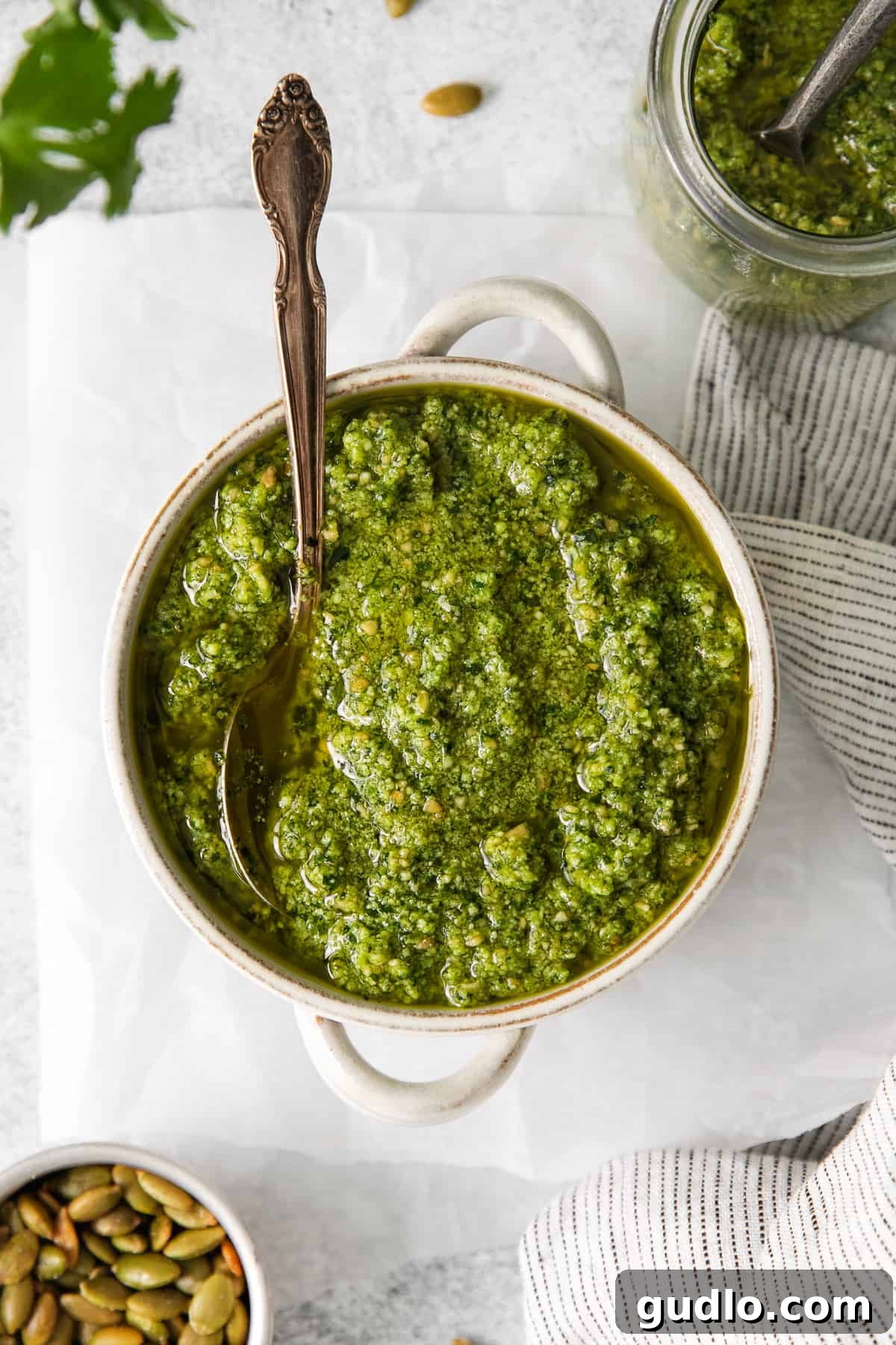 Cilantro pesto in a bowl with a spoon, ready to be served.