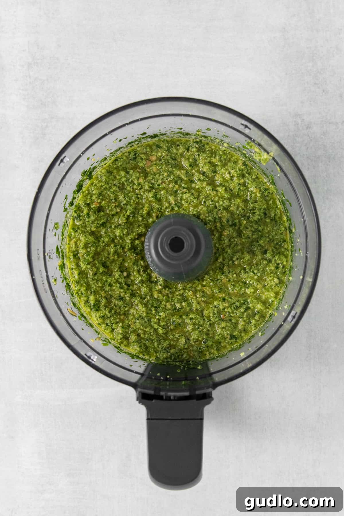 Blended cilantro pesto in a food processor, showing its smooth, vibrant green texture.
