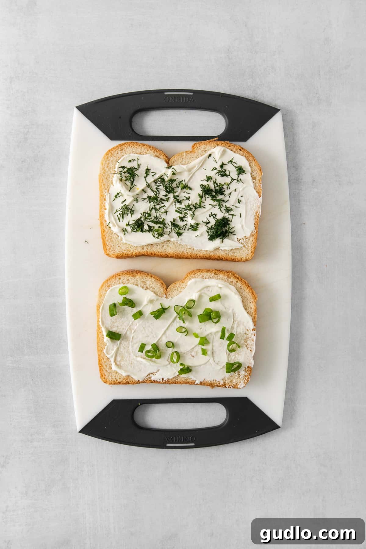 Refreshing Cucumber Cream Cheese Sandwiches 4 Cream cheese and dill spread on a slice of white bread, ready for cucumber slices.