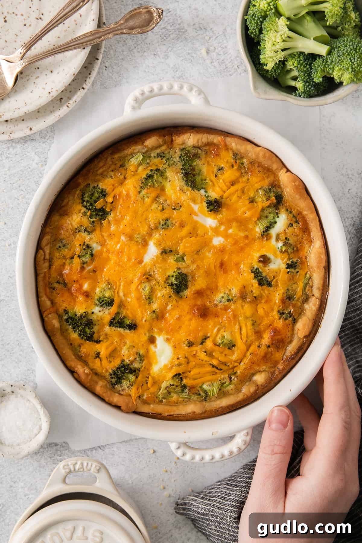 A vibrant, cheesy broccoli quiche in a pie dish, ready to be served.