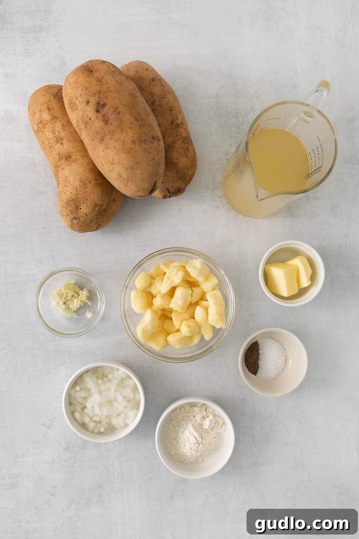 A rustic table setting featuring a large bowl of poutine, fresh potatoes, and other ingredients, highlighting the dish's wholesome origins.