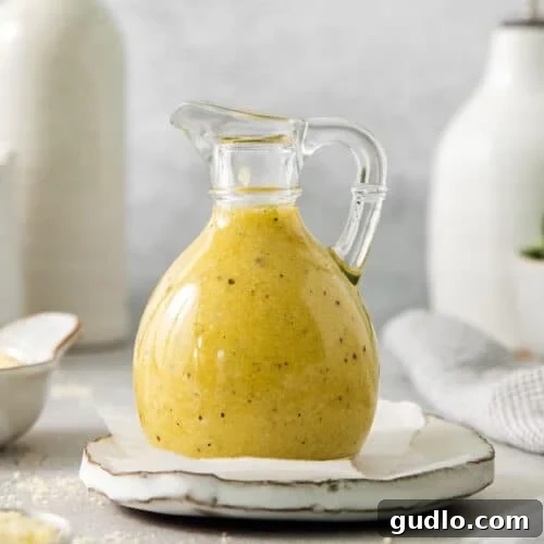 A bottle of rich, creamy Parmesan cheese dressing, elegantly styled on a plate, ready to be drizzled.