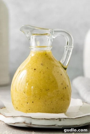 A bottle of Parmesan cheese dressing next to a bowl of salad, ready to be enjoyed.